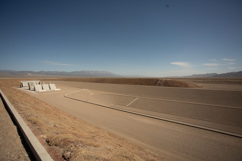 Michael Heizer city desert pyramids with mountains in the distance