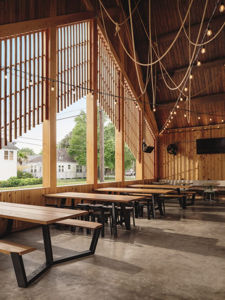 Timber details of gabled Texas restaurant with long tables in front of window