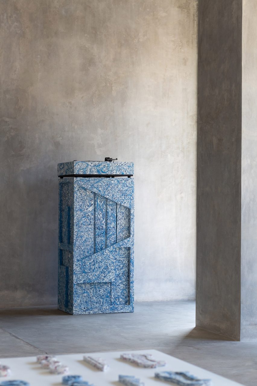 Recycled plastic sculptural object sits in a concrete-walled gallery