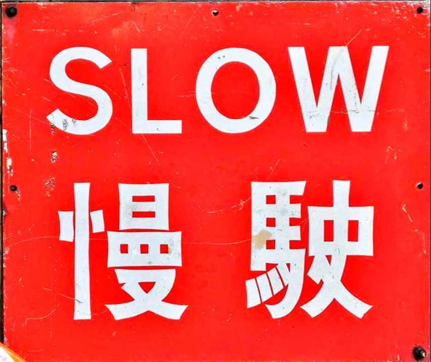 A red slow down road sign