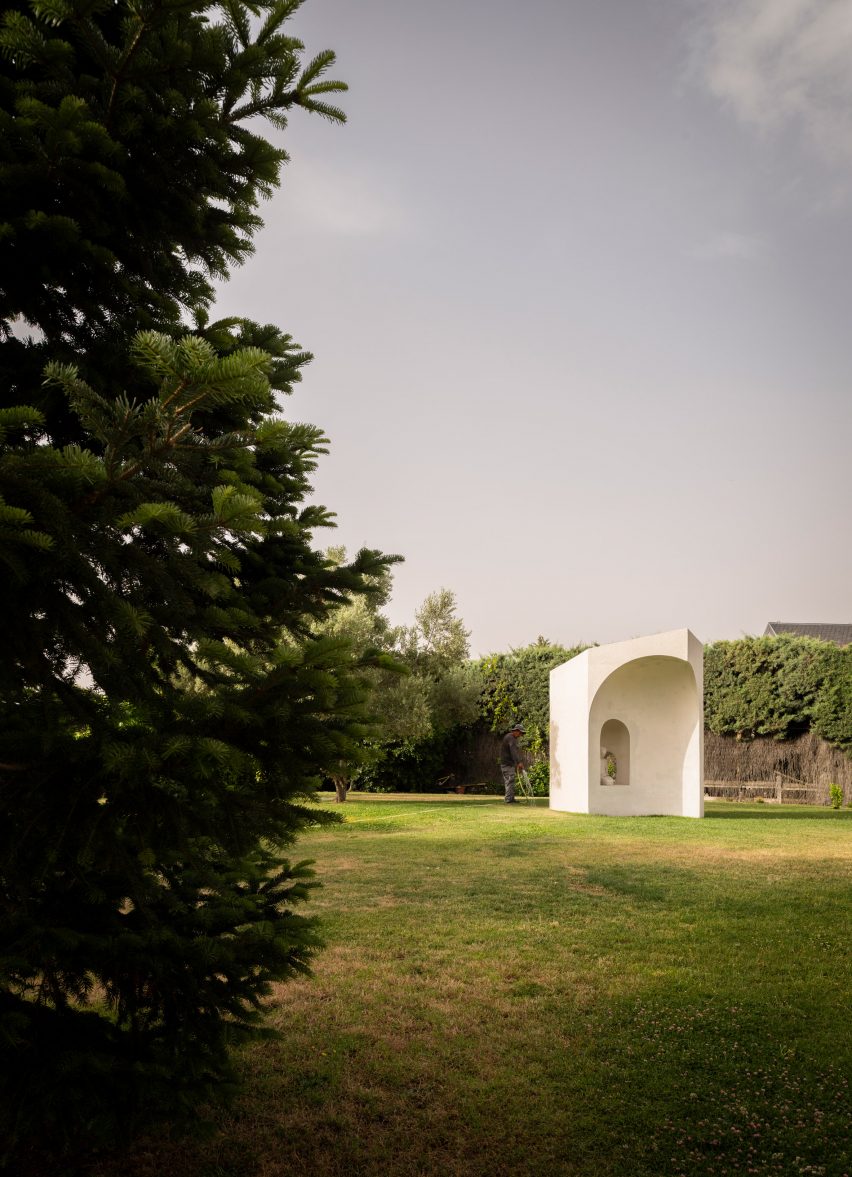 Белый мемориал Рамоса Альдерете в саду.