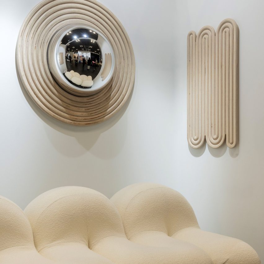 Photograph showing sofa, wall decor and mirror in brightly-lit show room