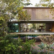 Exterior of Casa Azul by Studio MK27 showing the rainforest through the other side of the building