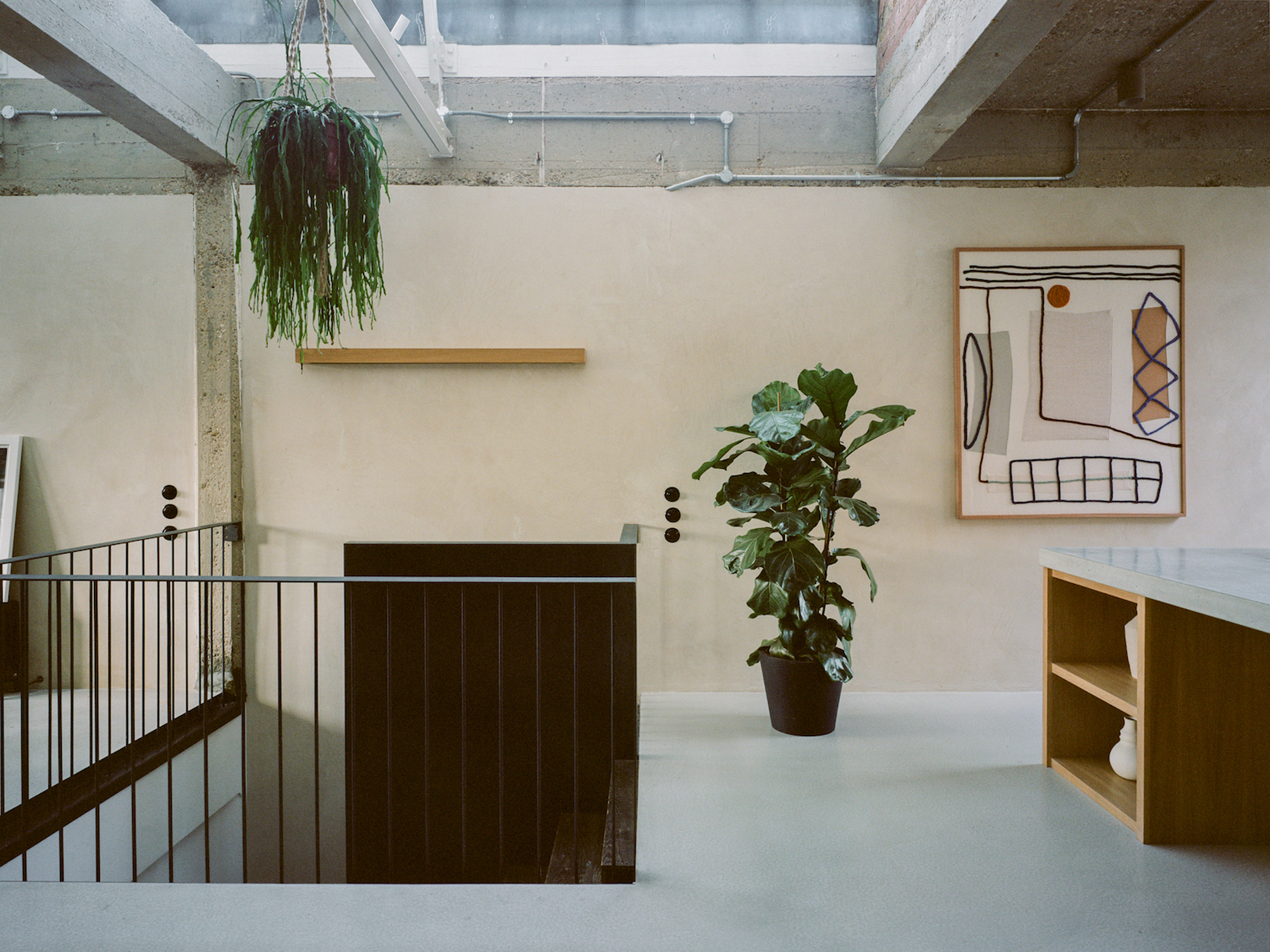 Clay and concrete interior with plants and staircase in Earthrise's Hackney office by Studio McW