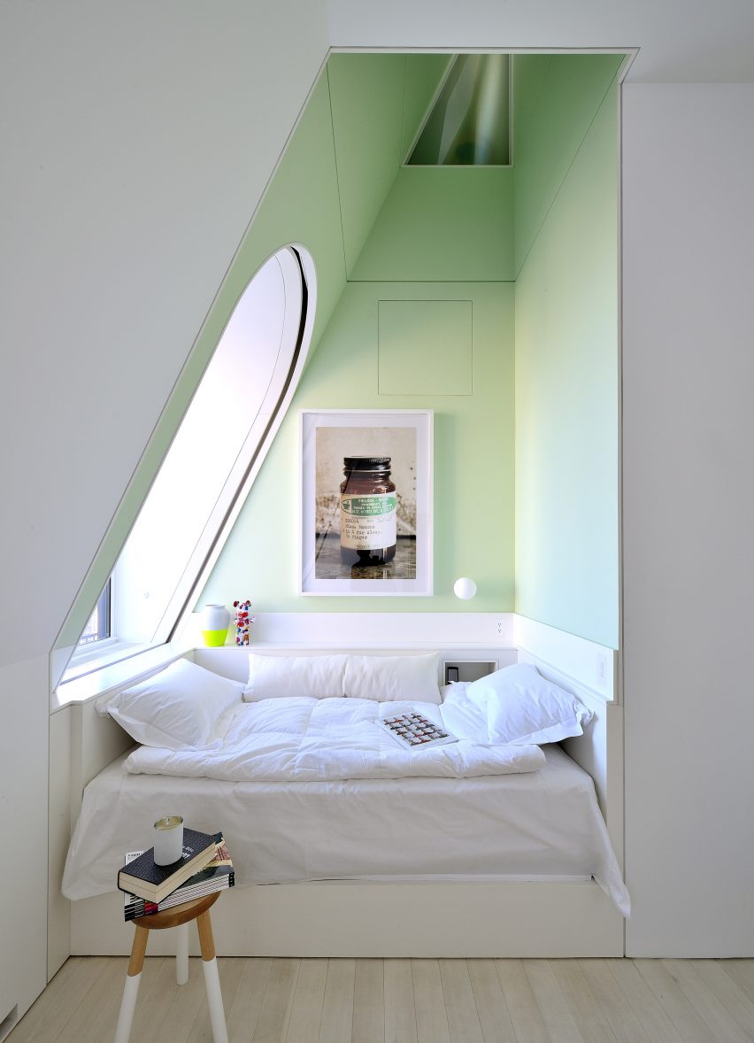 Pale green triangular recess with children's bed and rounded window