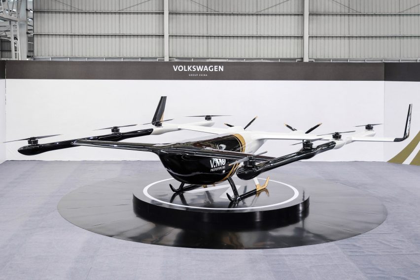 A white and black flying car inside a hangar