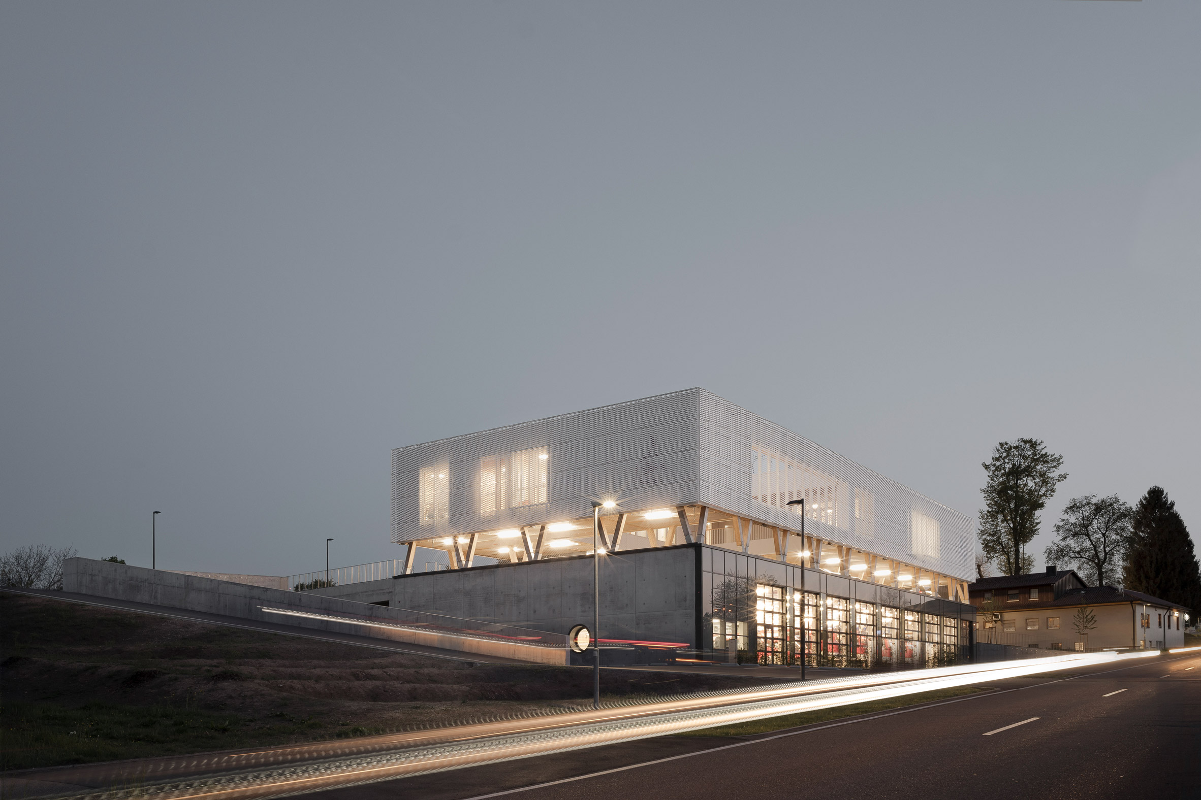 Perforated metal-clad concrete and timber fire station by Wulf Architekten