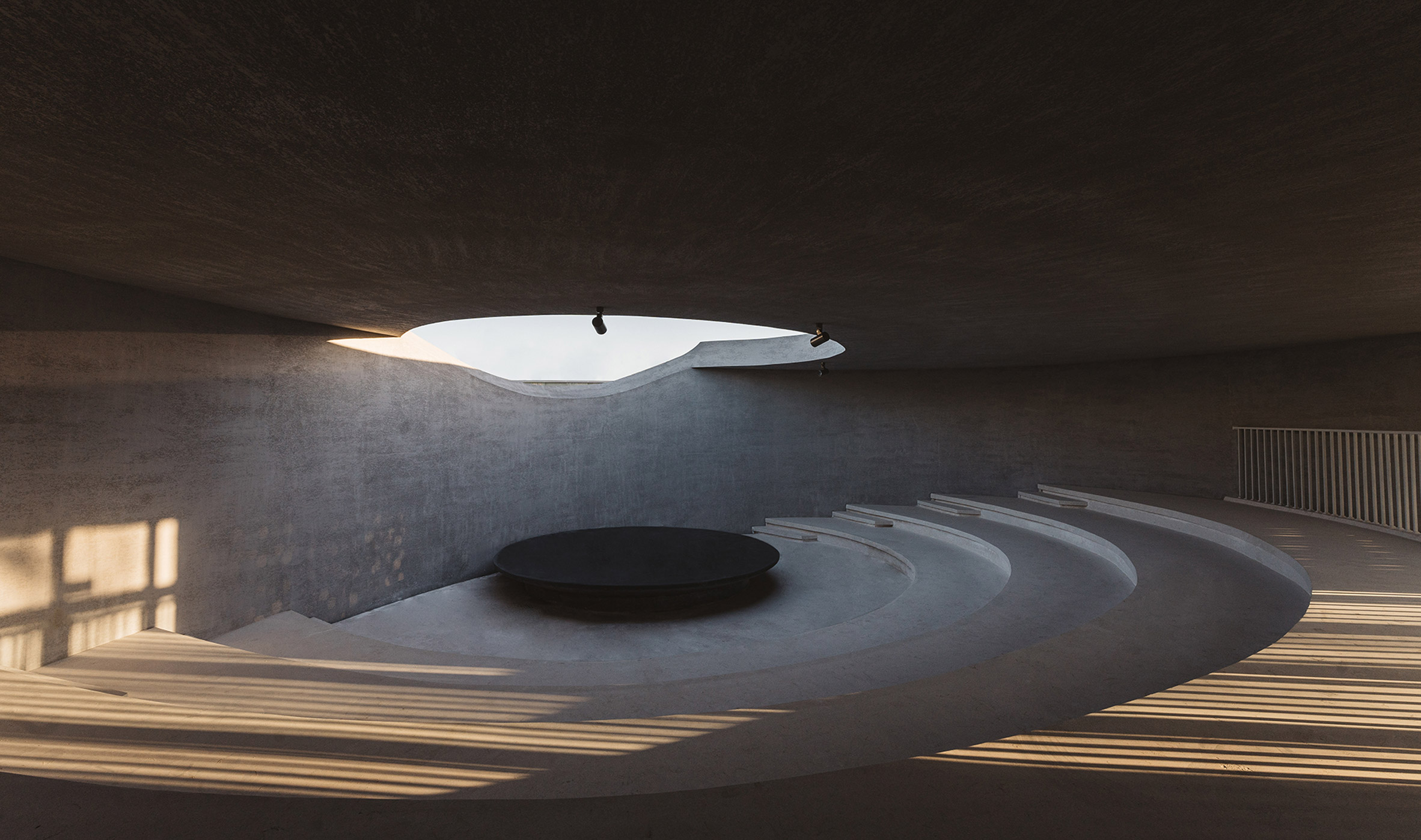 Auditorium with black stage illuminated by round skylight in China