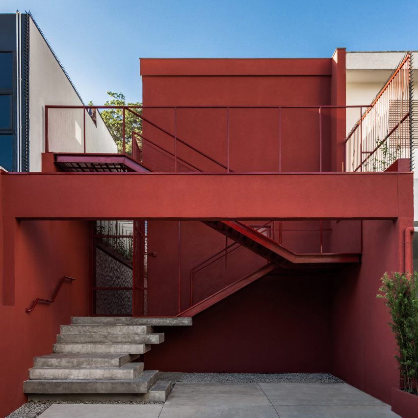 Front of the red Yoga House by Superlimao with exterior staircase