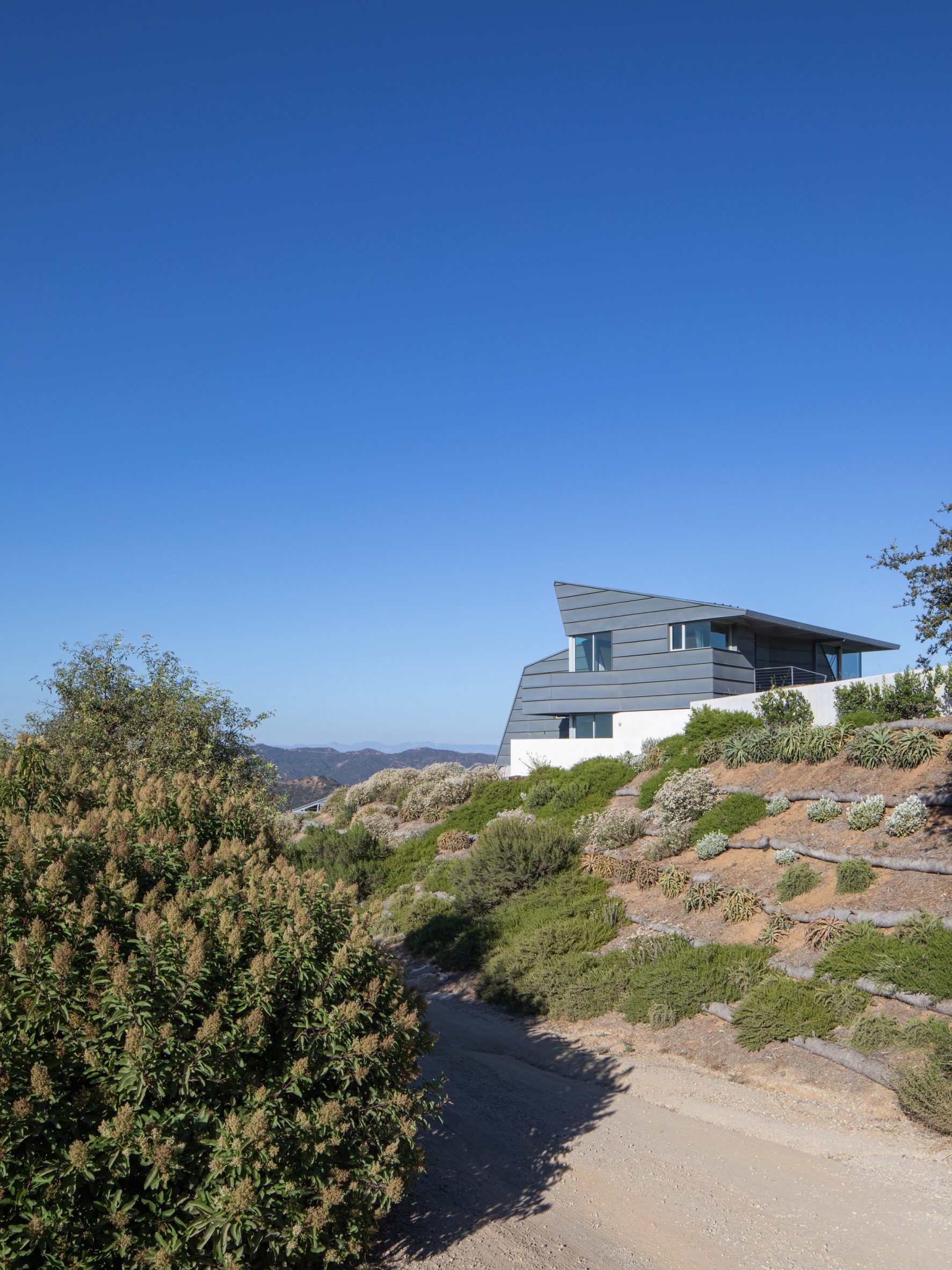4/Way House sitting on the top of a grassy hill
