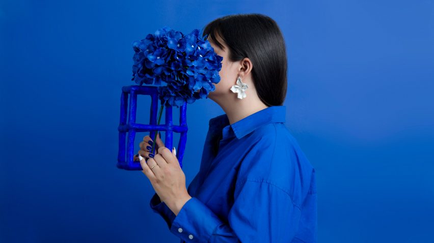 Image of a woman holding a blue design with a flower on it