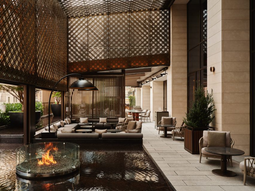 A circular fire pit sits within a square reflecting pool on the terrace