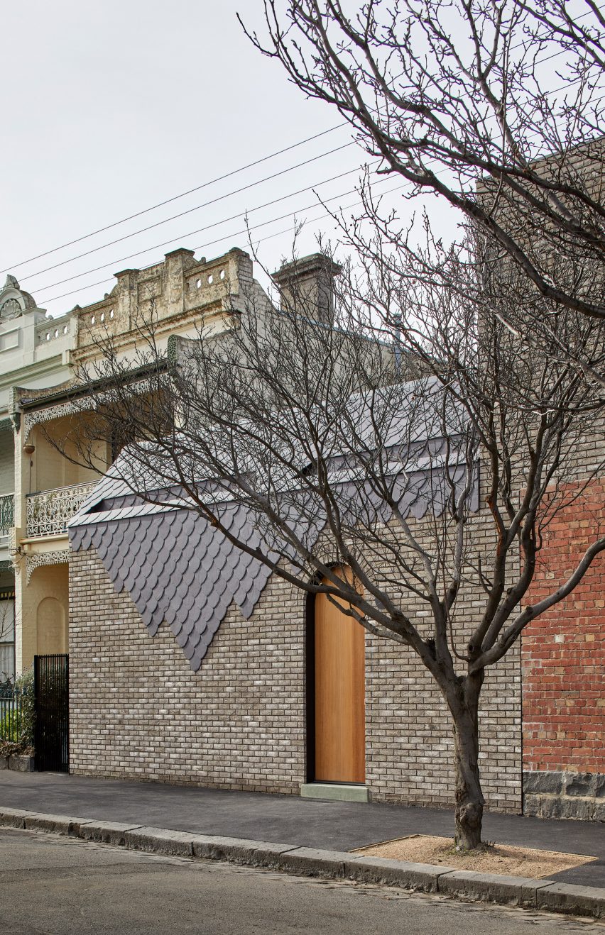 Curved slate tiles on brick building by Angelucci Architects
