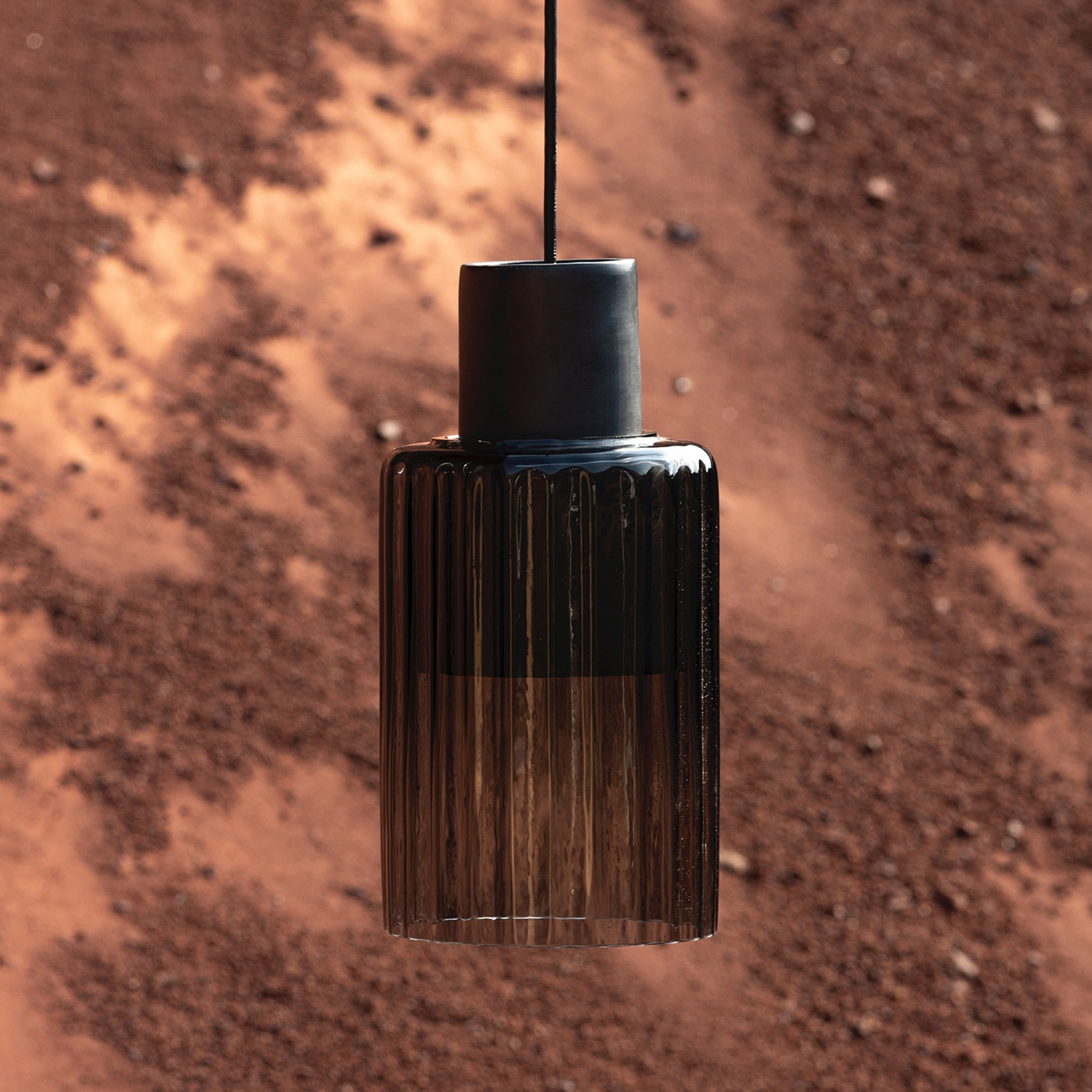 Photograph of black ceiling lamp Barro made using clay and glass materials