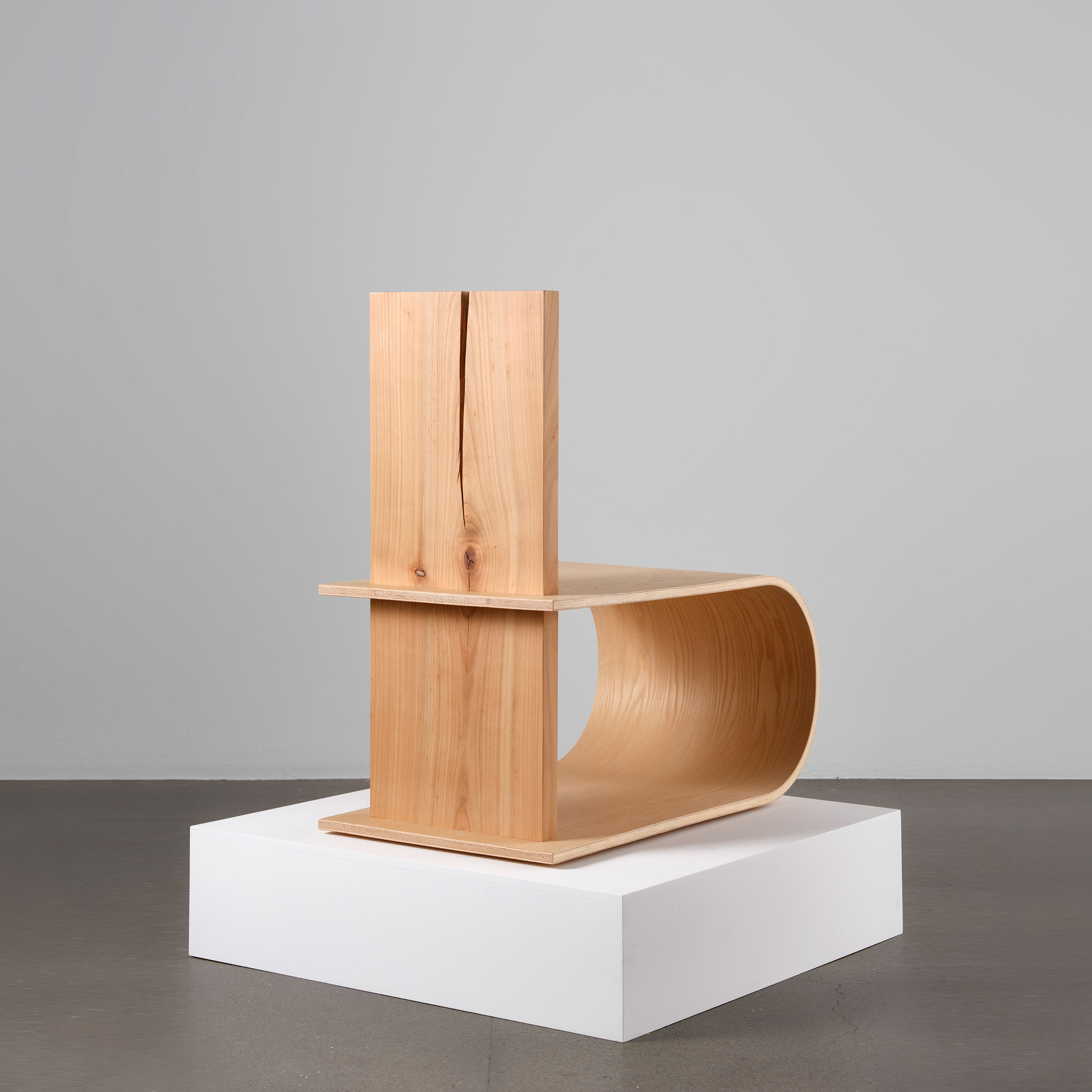Photograph showing wooden chair on white plinth