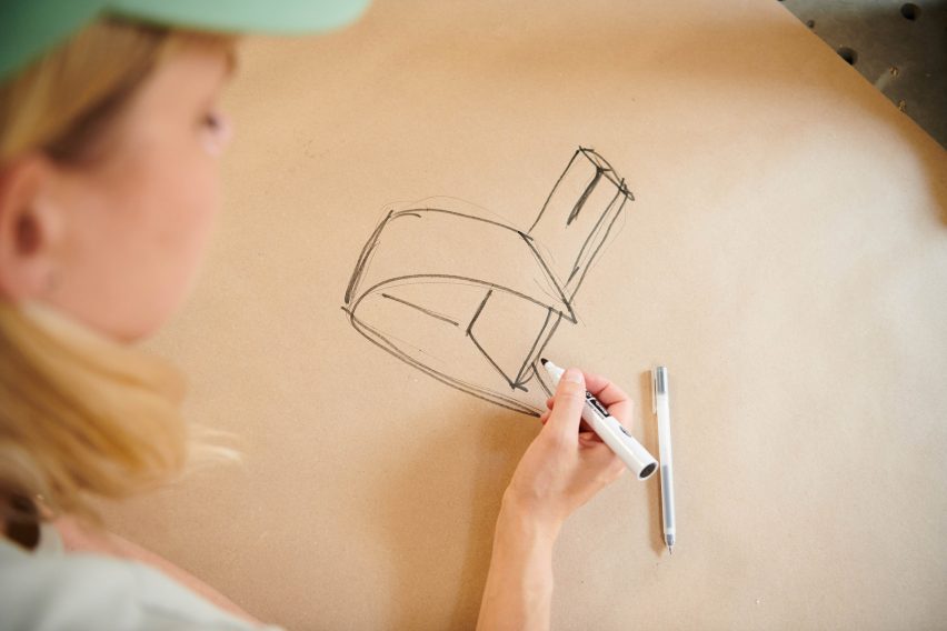 Photograph showing Anne Brandhoj drawing design for chair on paper