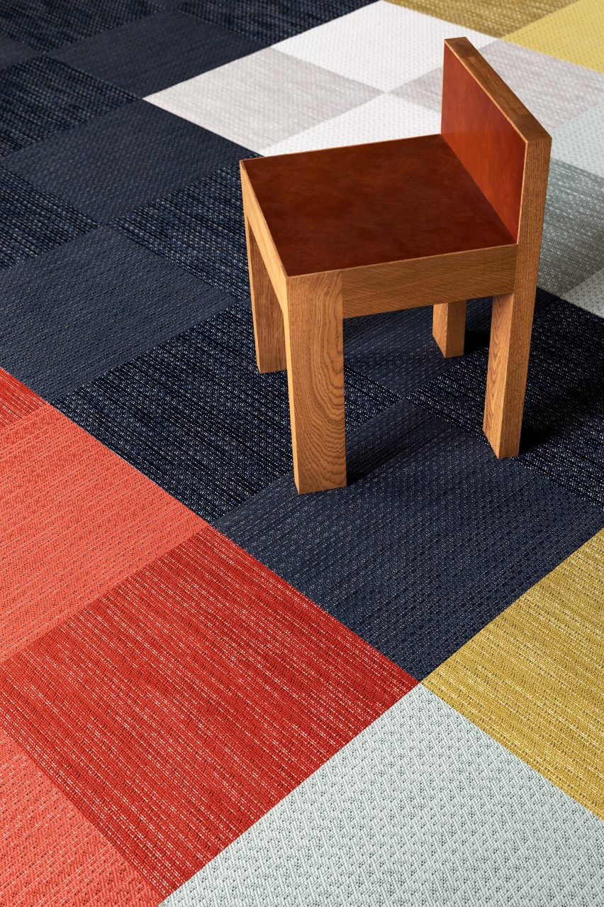 Dark blue, red and light blue square carpet tiles with a wooden chair