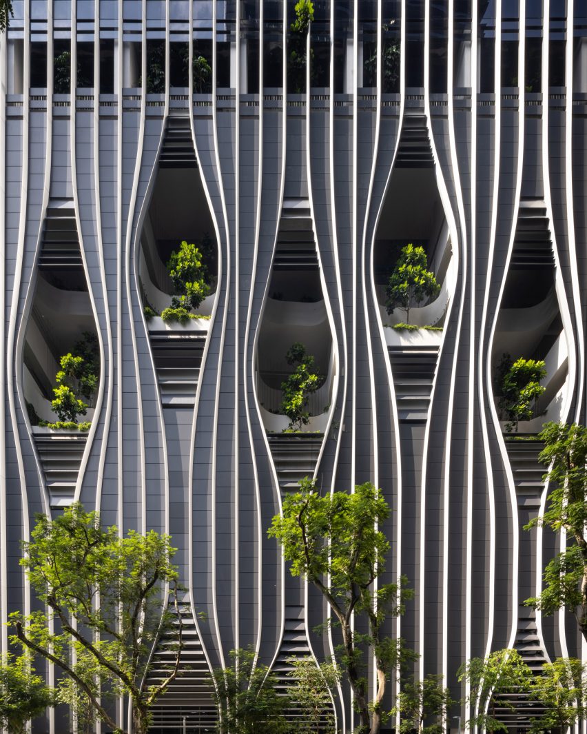 Facade with sculptural openings framing plants