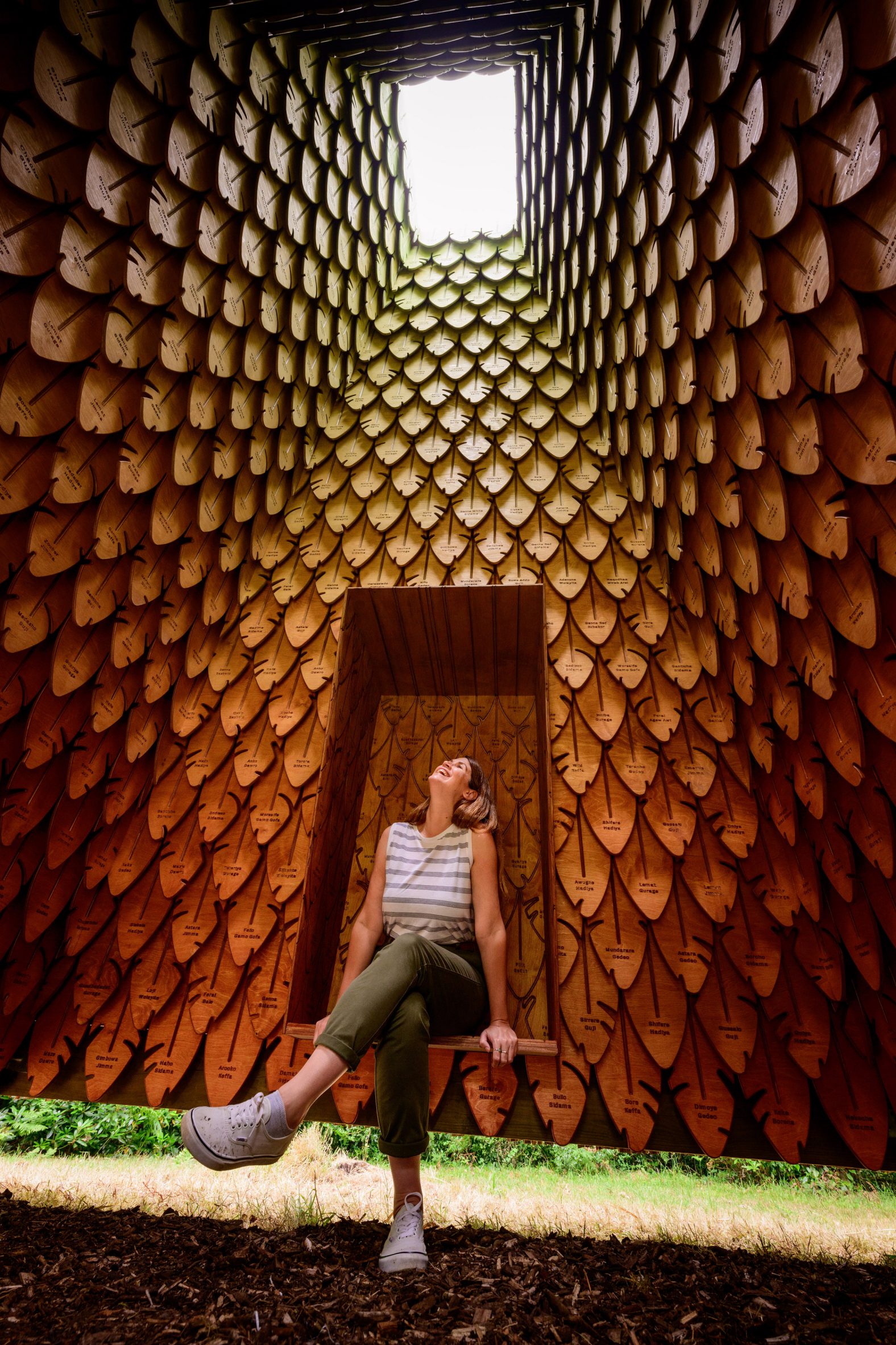 Woman sat on seat in False Banana Pavilion by Flea Folly Architects