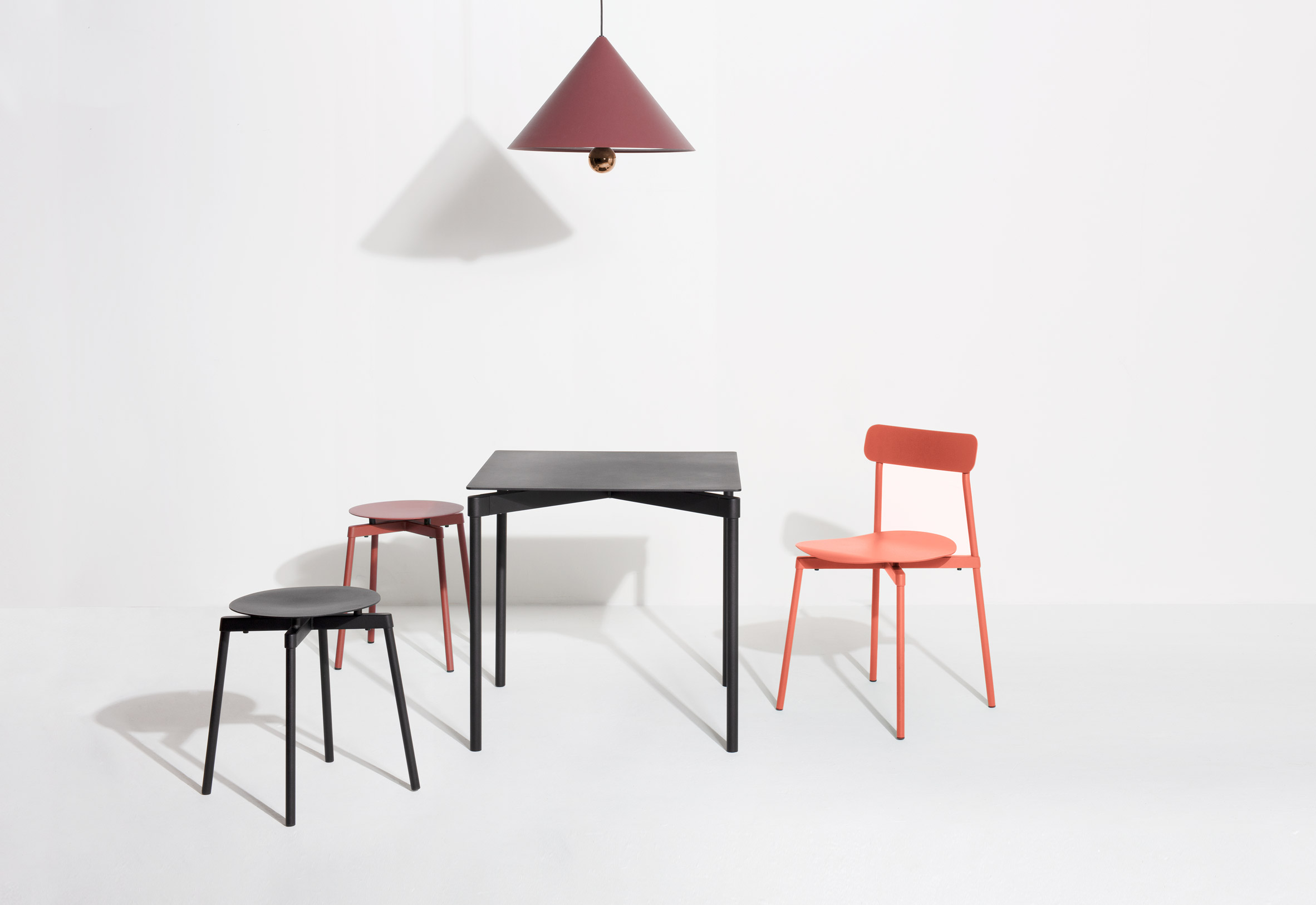 Orange Fromme chair by Petite Friture with the collection of stools and dining table