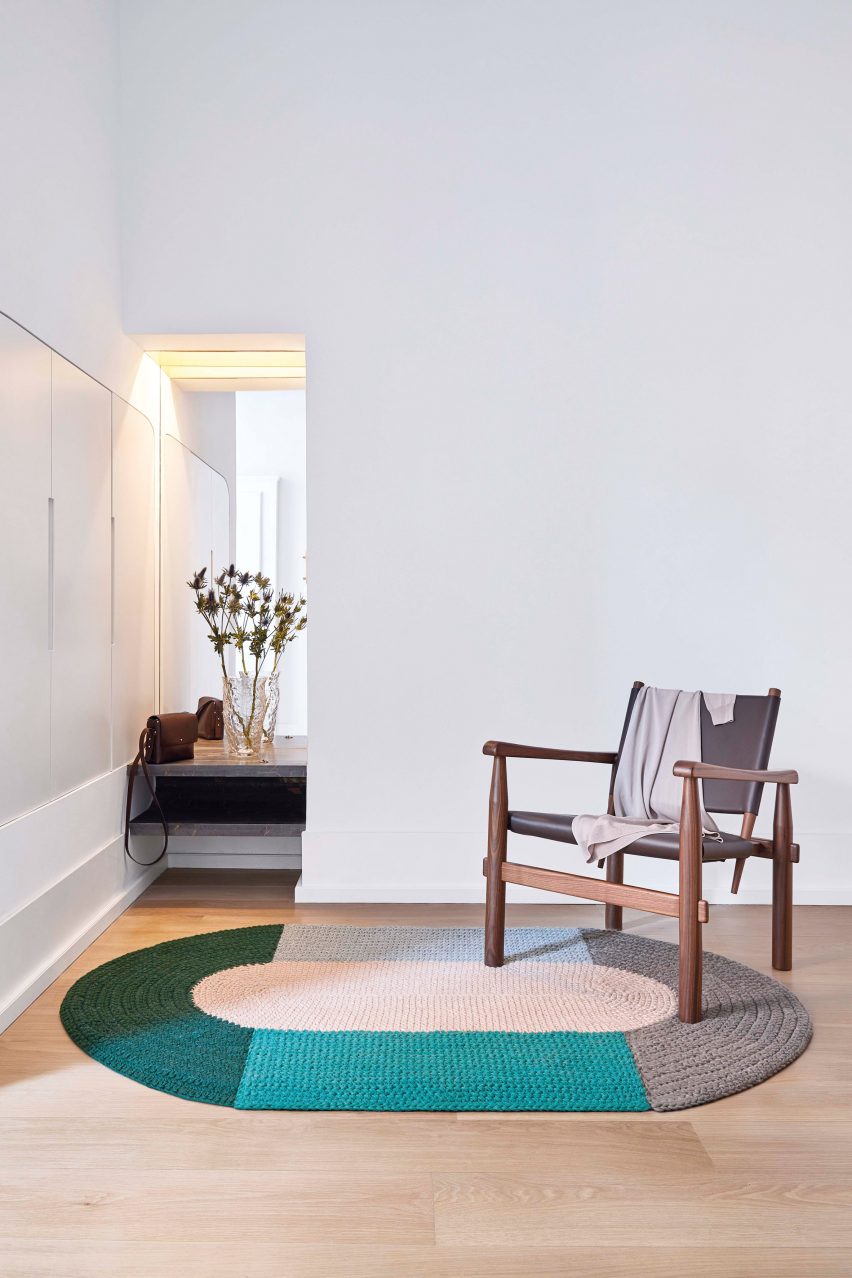 Large crochet rug from Gan in an open space with an armchair
