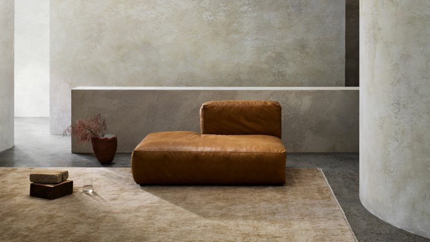 Photograph showing warm neutral rug and orange leather seat