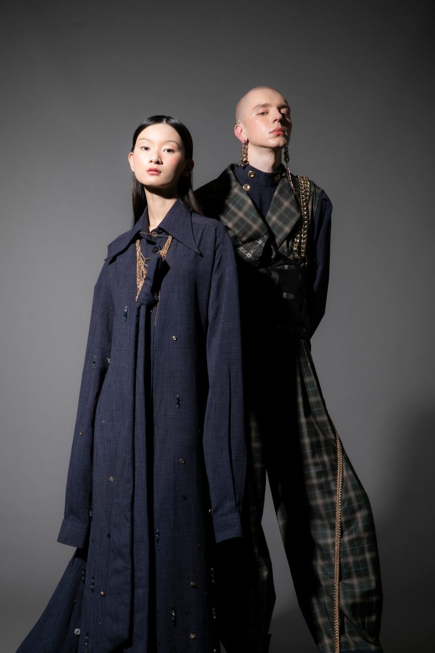 Photograph showing two models in dark clothing on dark backdrop