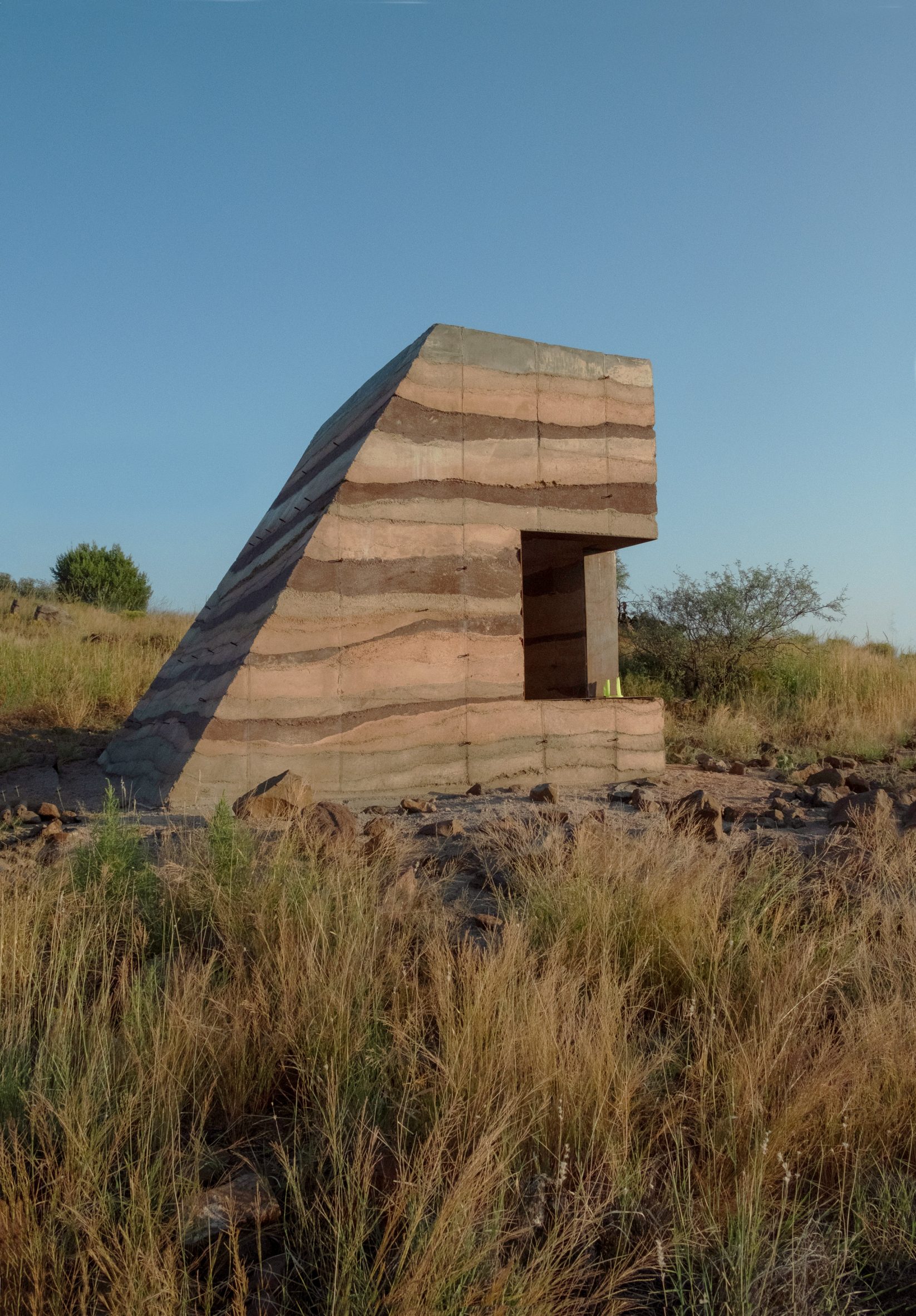 Rammed-earth shelter with window in the side
