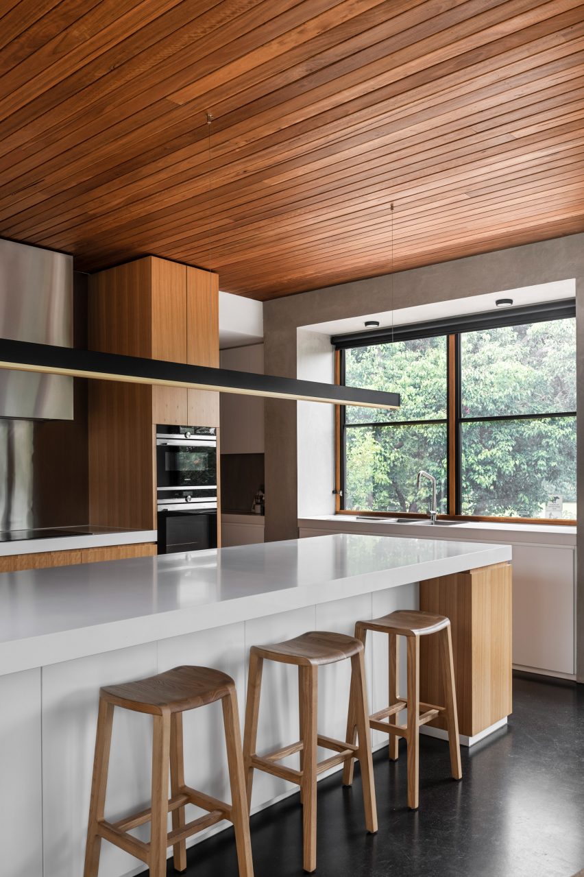 Kitchen with timber ceiling and white island by BKK Architects