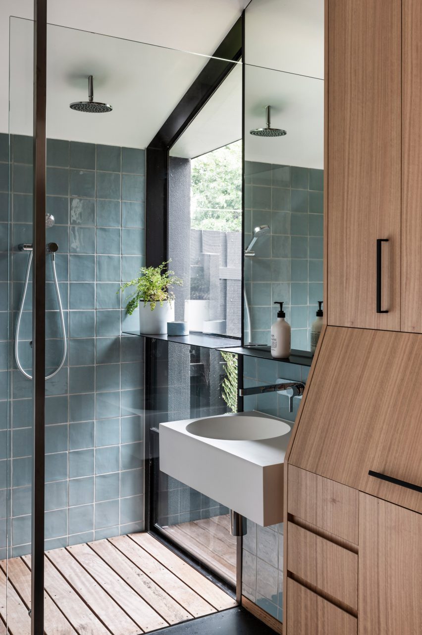 Children's bathroom with glass-walled shower and timber cabinets