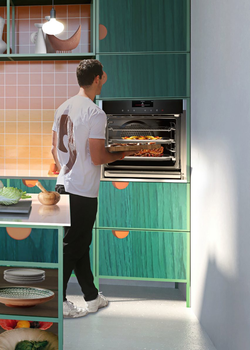 Pria yang menggunakan oven Neff Slide & Hide di dapur kontemporer berwarna hijau