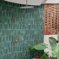 Photograph of bathroom with green tiles laid vertically in shower enclosure