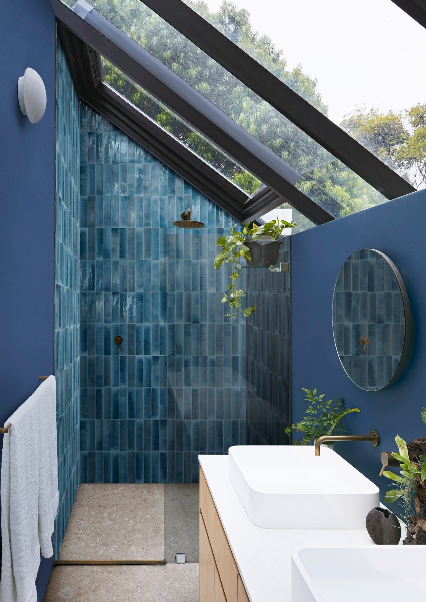 Фотография ванной комнаты с темно-синей плиткой, уложенной вертикально внутри душевой кабины