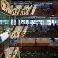 Weathered-steel staircase wraps plant-filled atrium at Midtown Workplace