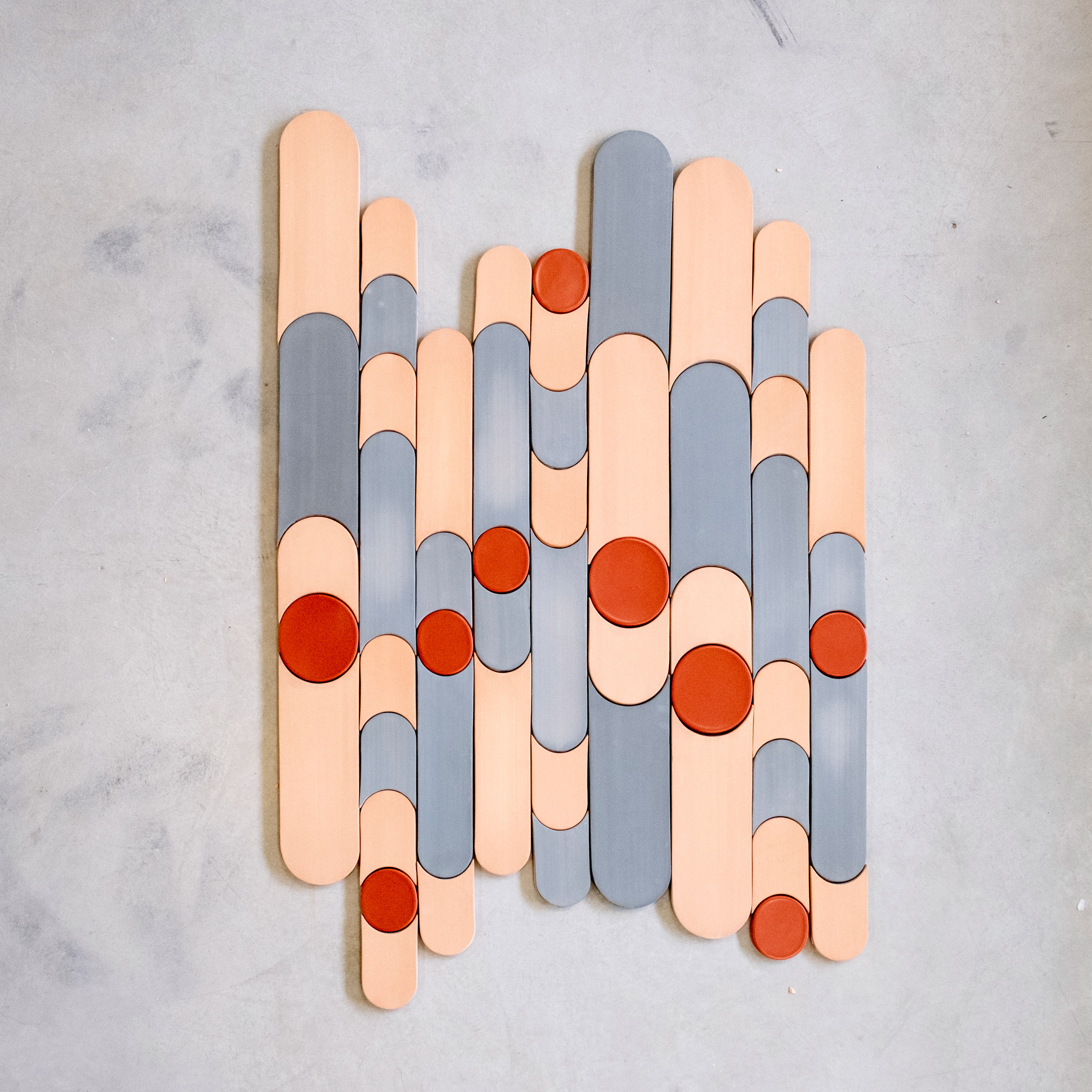 Circle and rounded Parquet Bisque tiles by New Terracotta in grey, peach and red