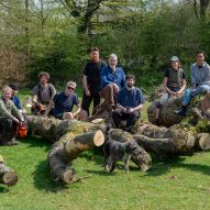Photograph showing designers sat on and around felled tree