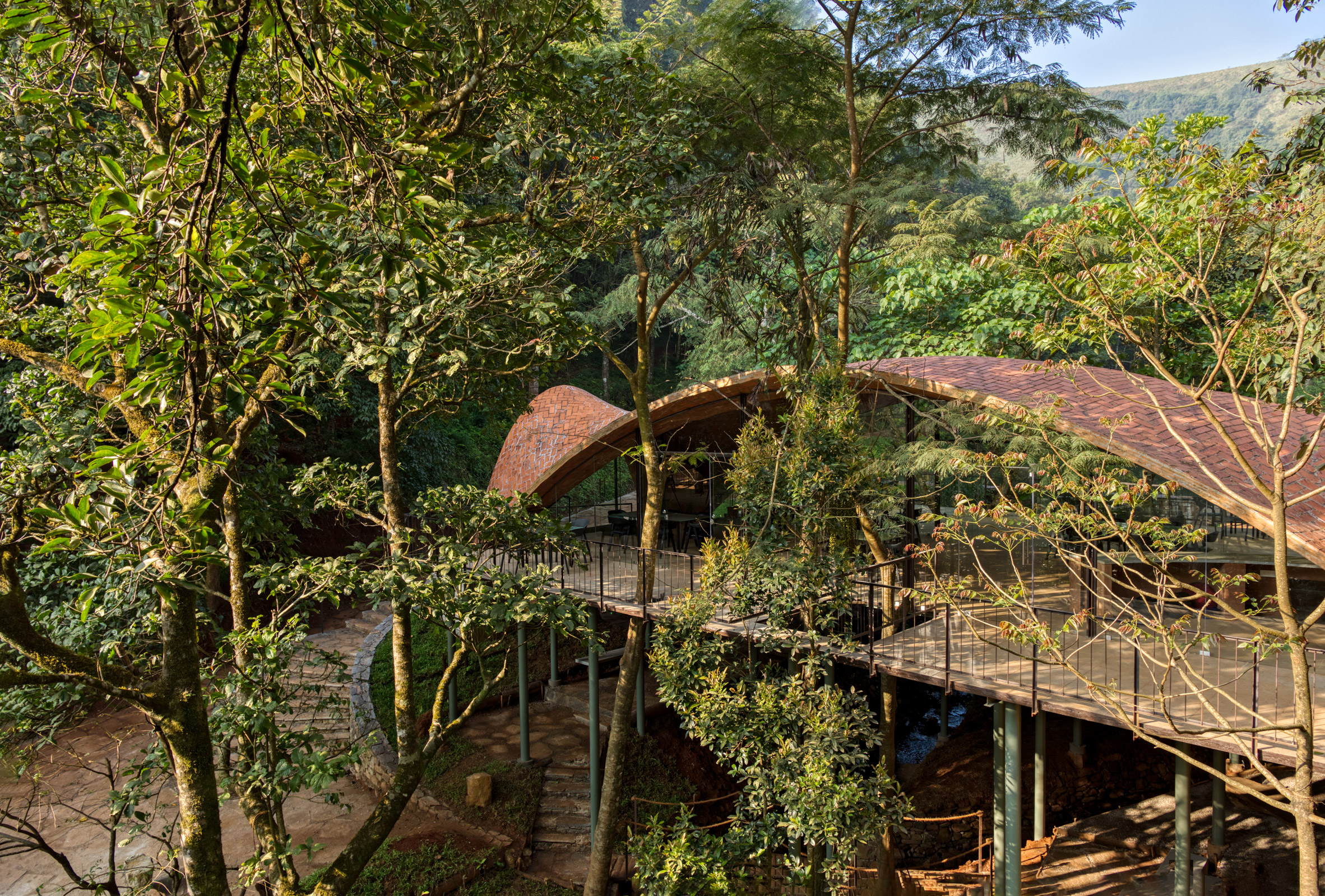 Vaulted tile roof over restaurant on deck in forest in India
