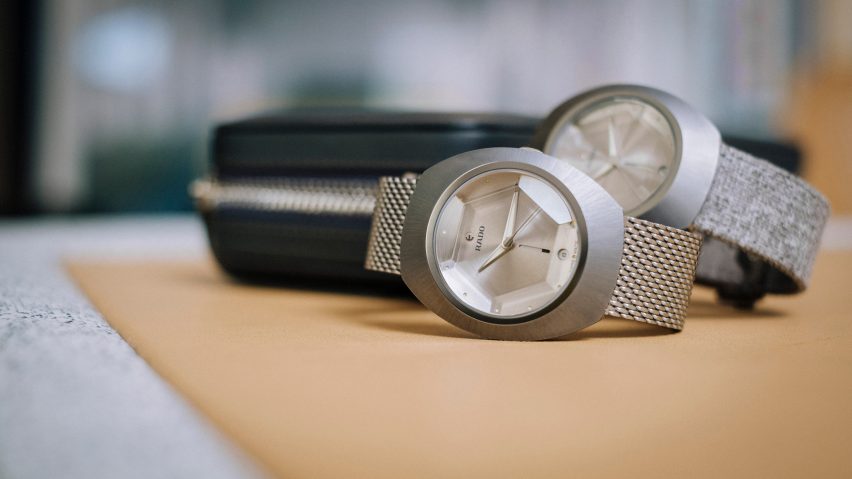 Two grey watches on a brown backdrop