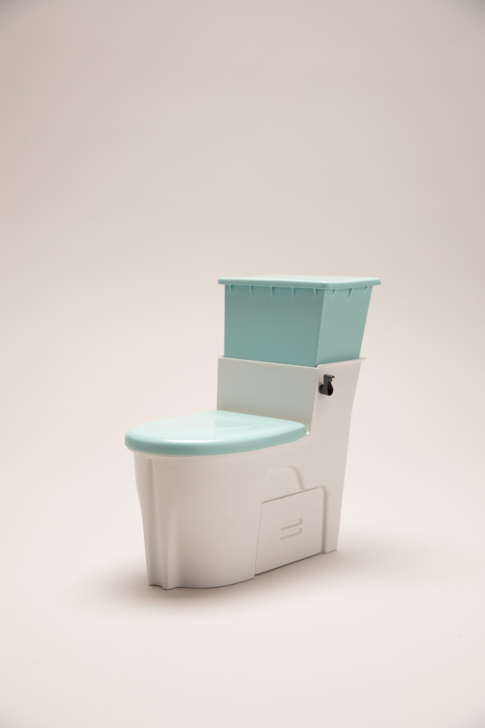 Scale model of a toilet made of white and aqua-coloured plastic