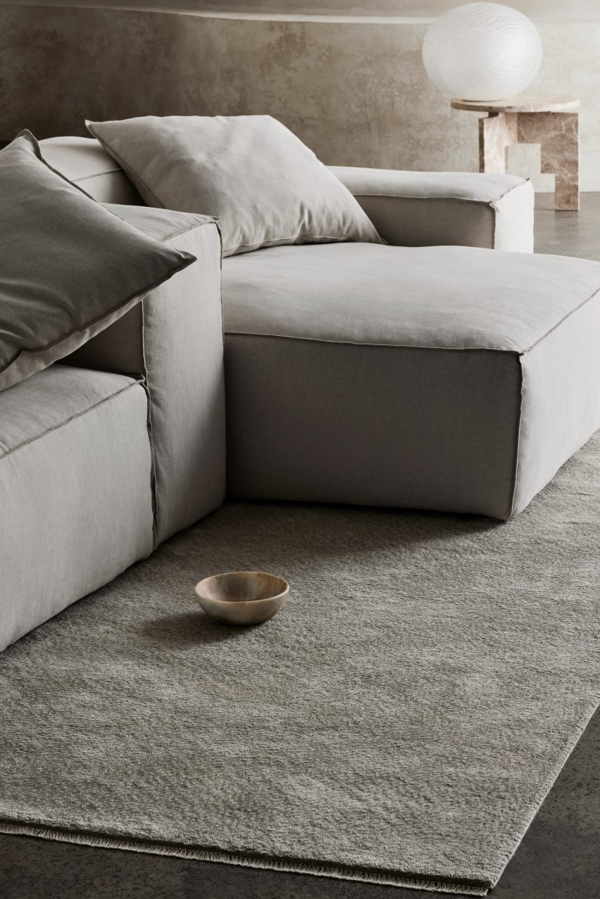 Photograph showing cool-toned living room with grey rug