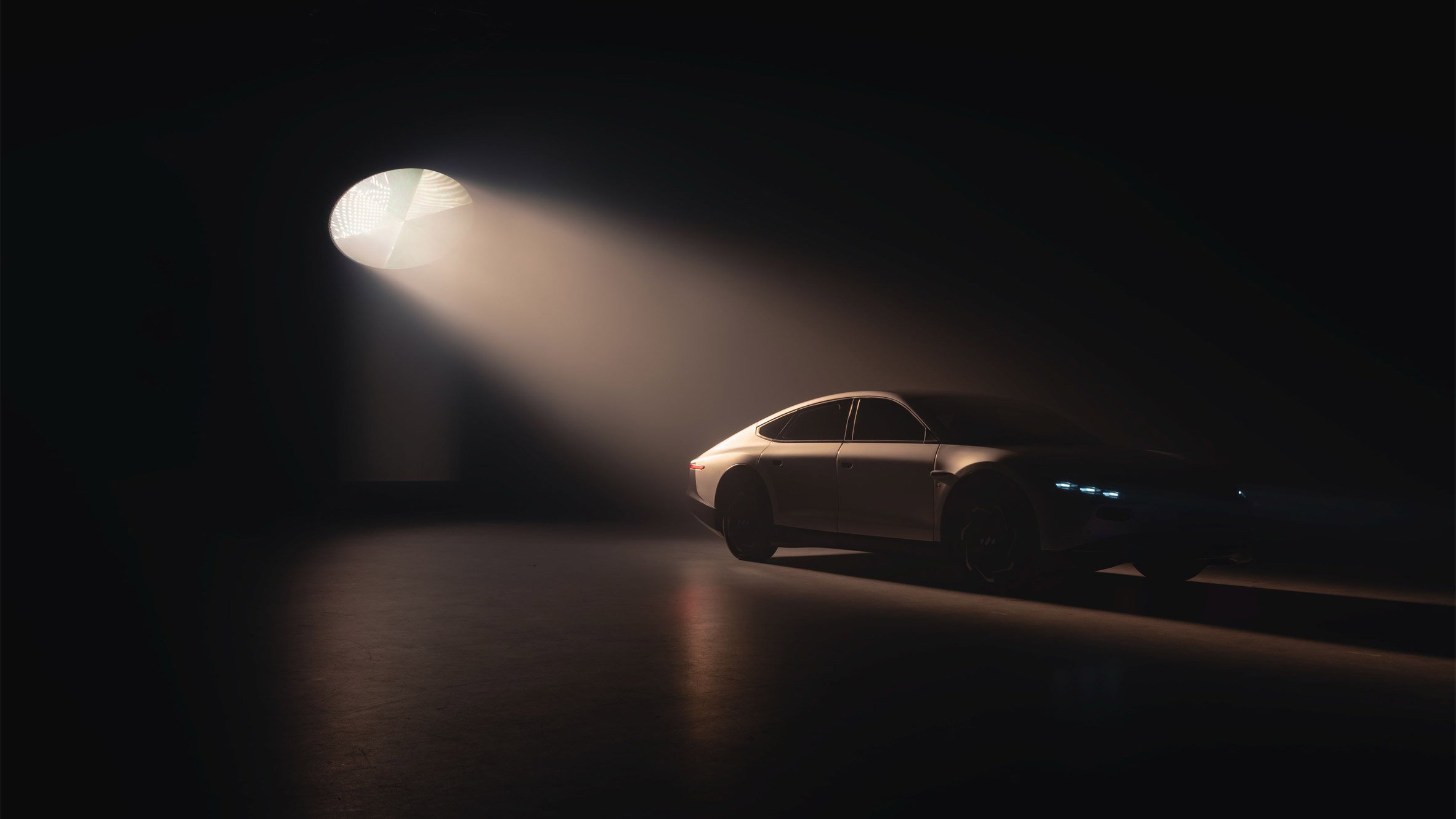 Lightyear 0 solar-powered car silhouetted against a black backdrop