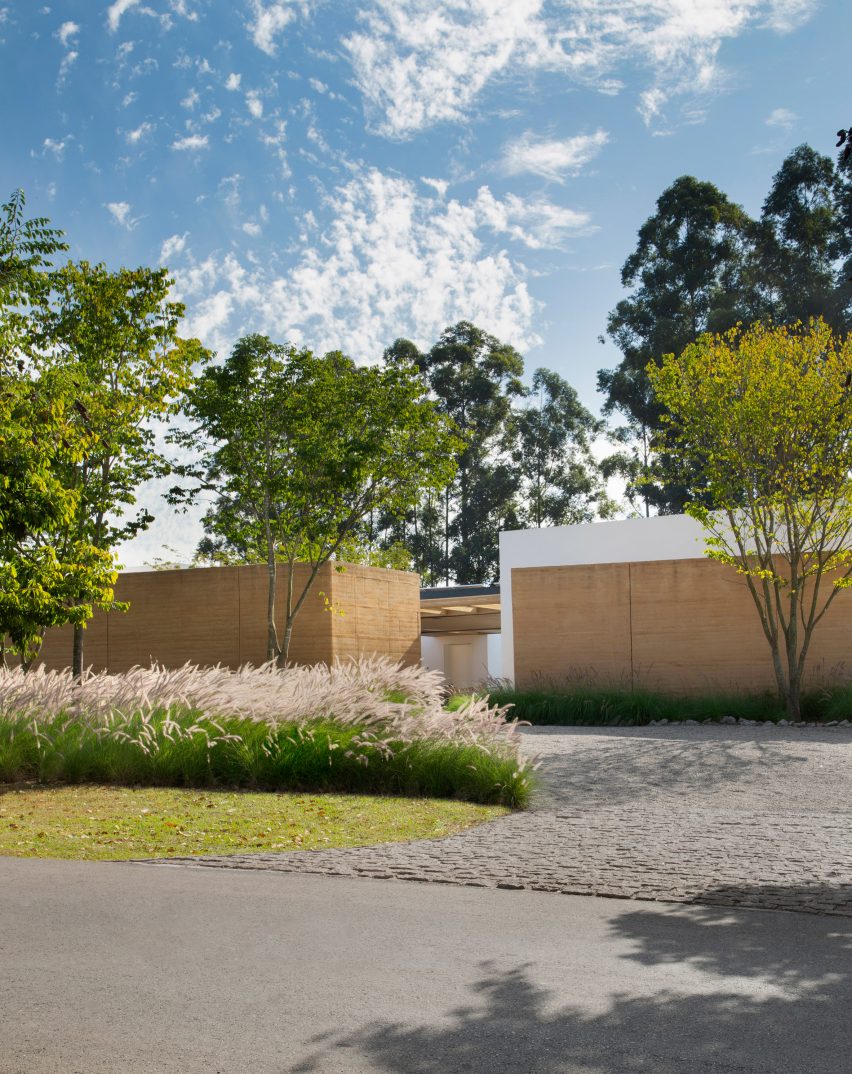Front garden of Brazilian villa with rammed earth walls