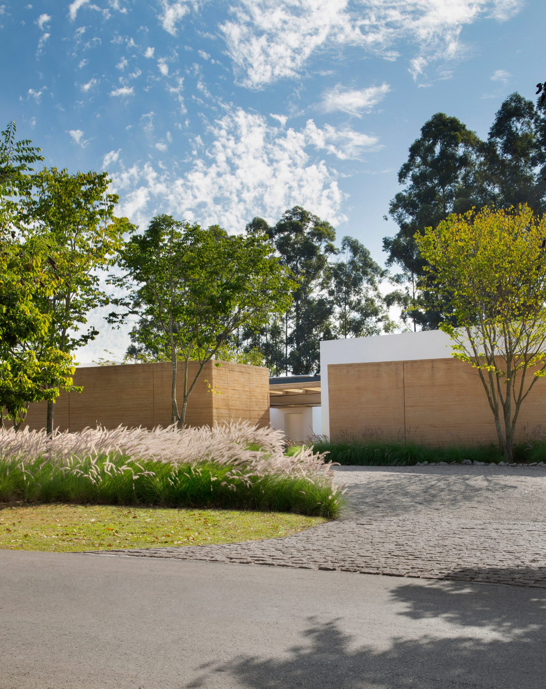 Front garden of Brazilian villa with rammed earth walls