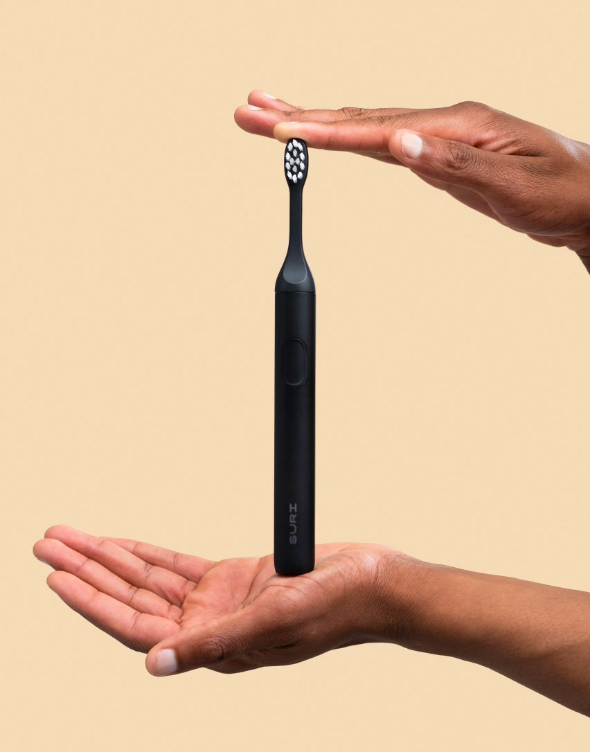 Two hands holding a black toothbrush