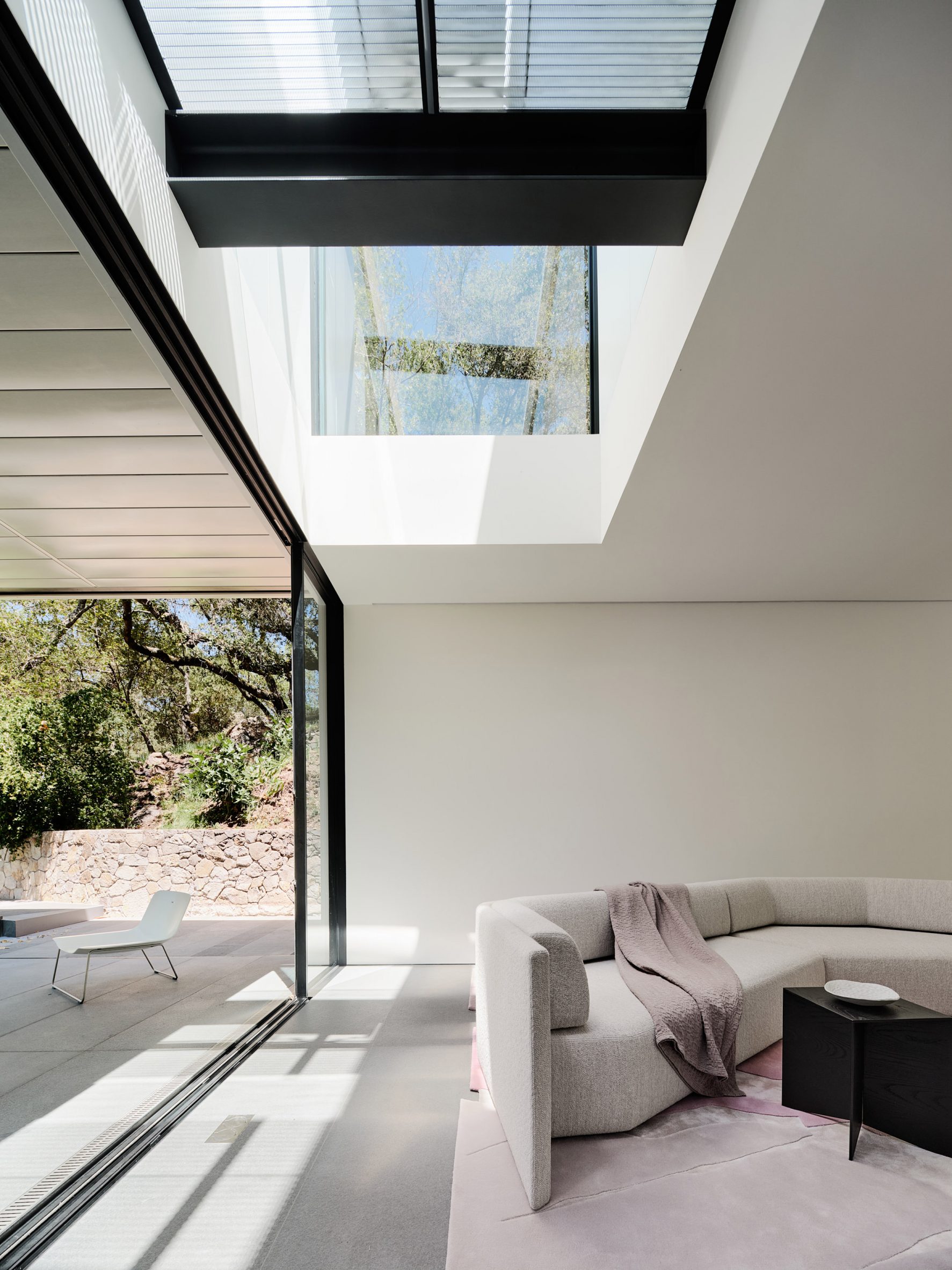 Living room in California house with glass wall and skylight