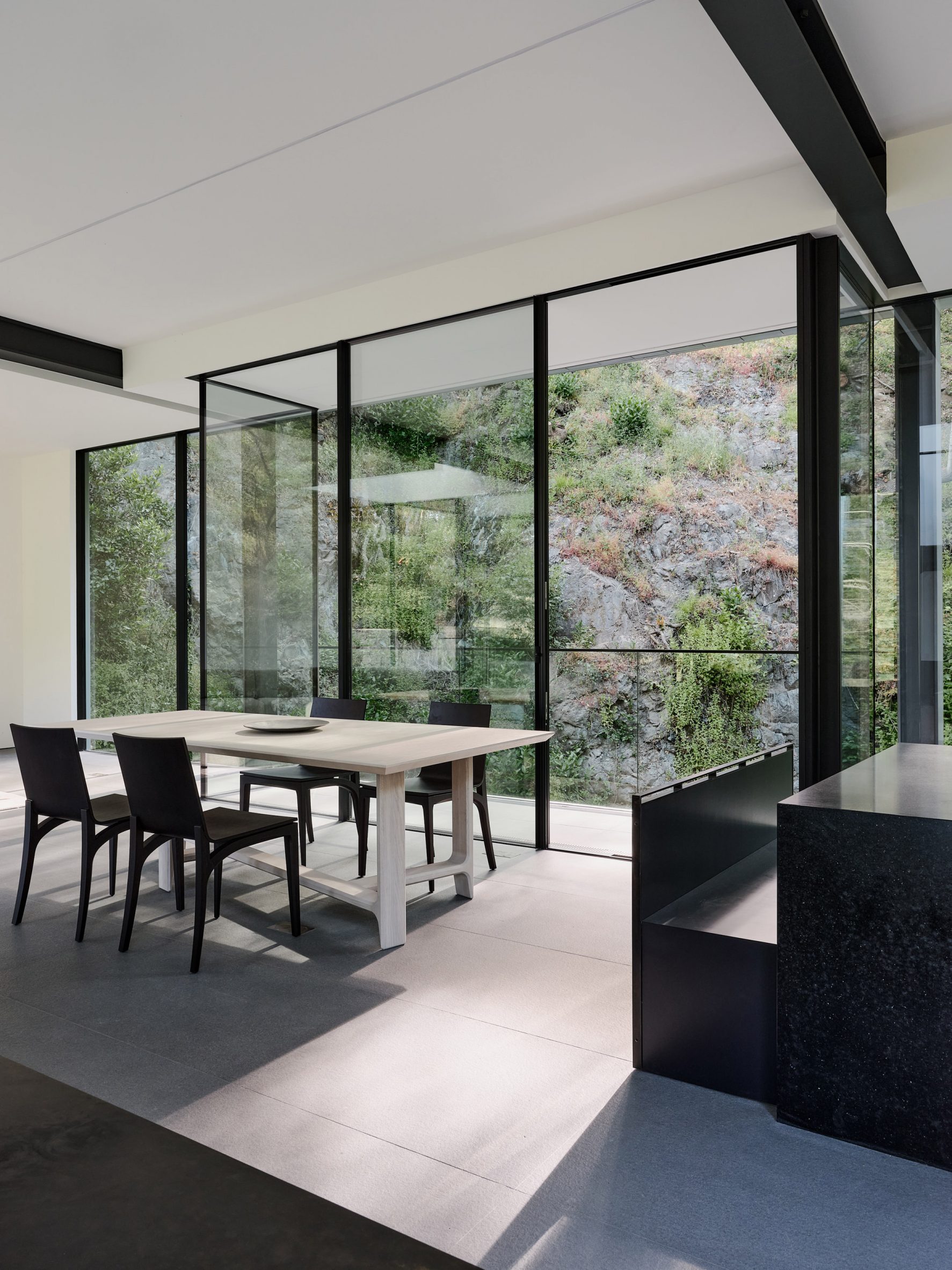 Kitchen with floor-to-ceiling glass windows with views of side of hill