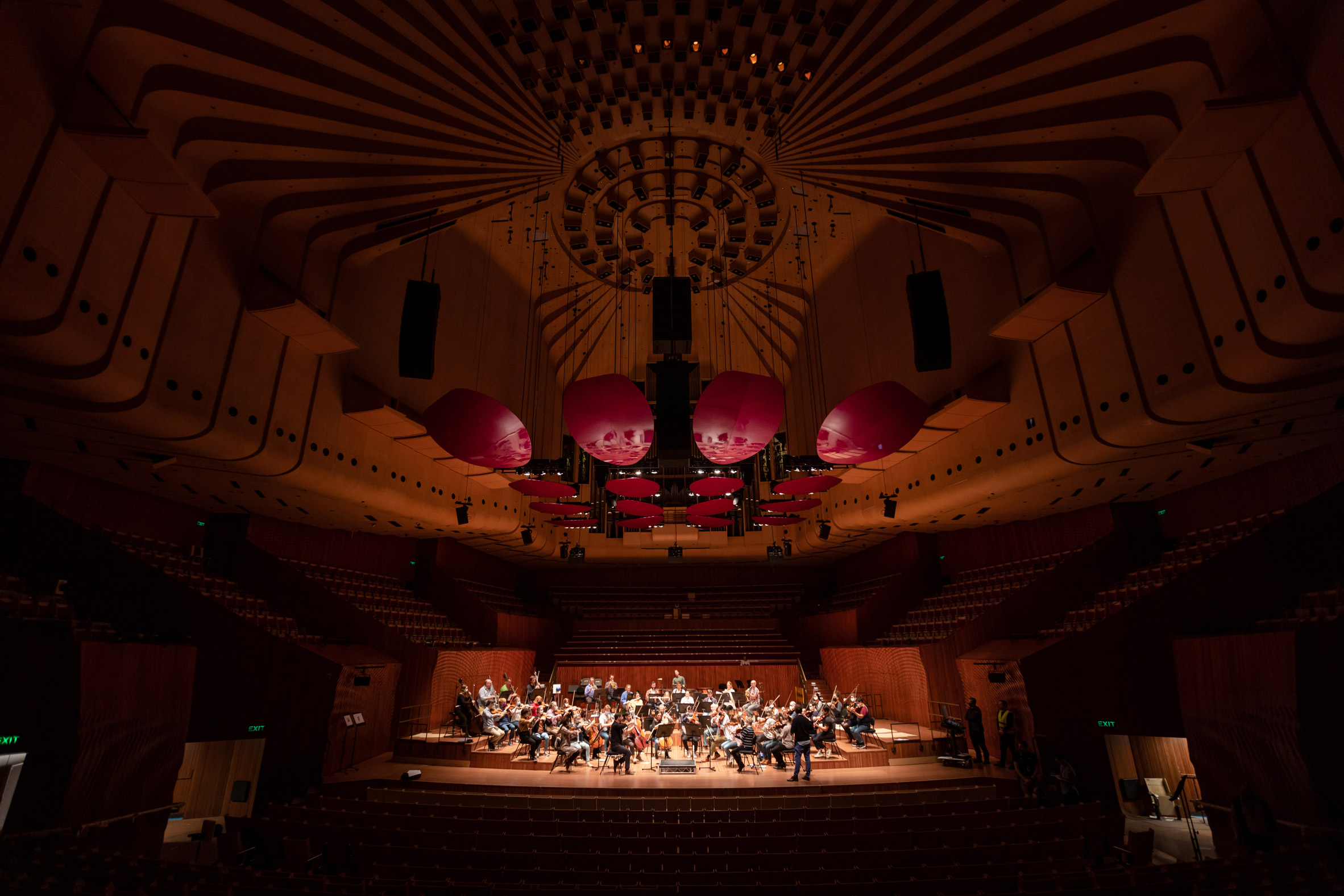 Orchestra rehearsing in an empty concert hall