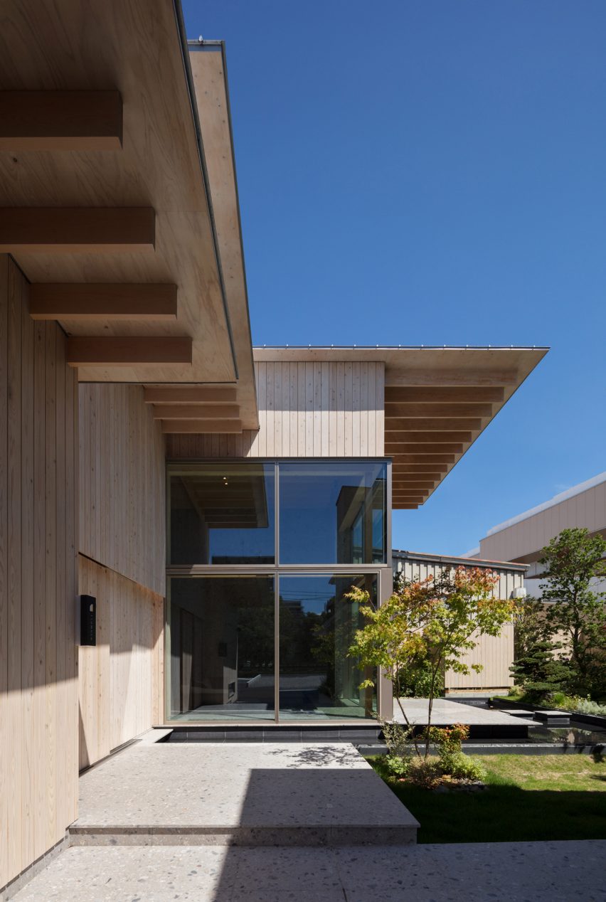 Wooden exterior of a Japanese house by Archipatch with overhangs and glass walls