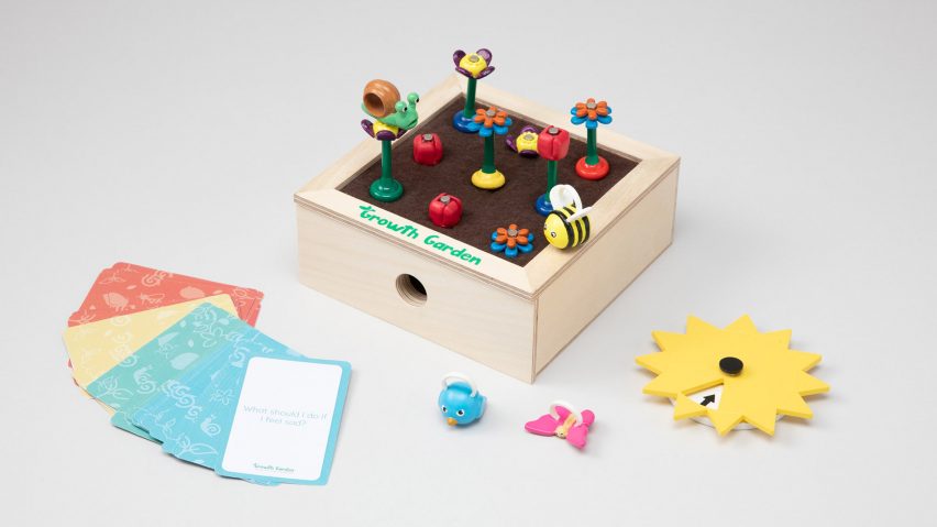 Child's box toy with bees and flowers on springs and playing cards to the side