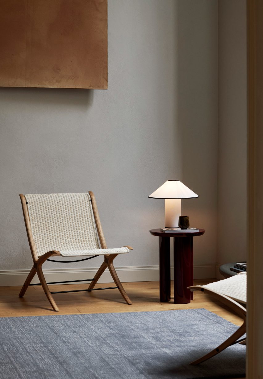 Photograph showing rattan and wooden chair by side table with lamp